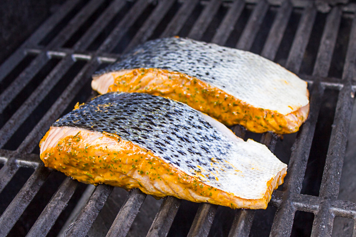 salmon fillets grilling face down on grates