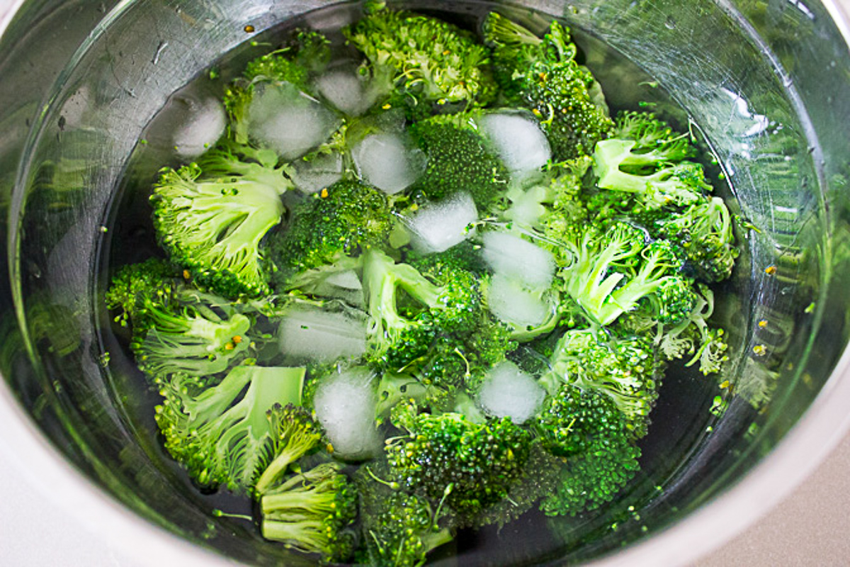cooked broccoli florets in ice water