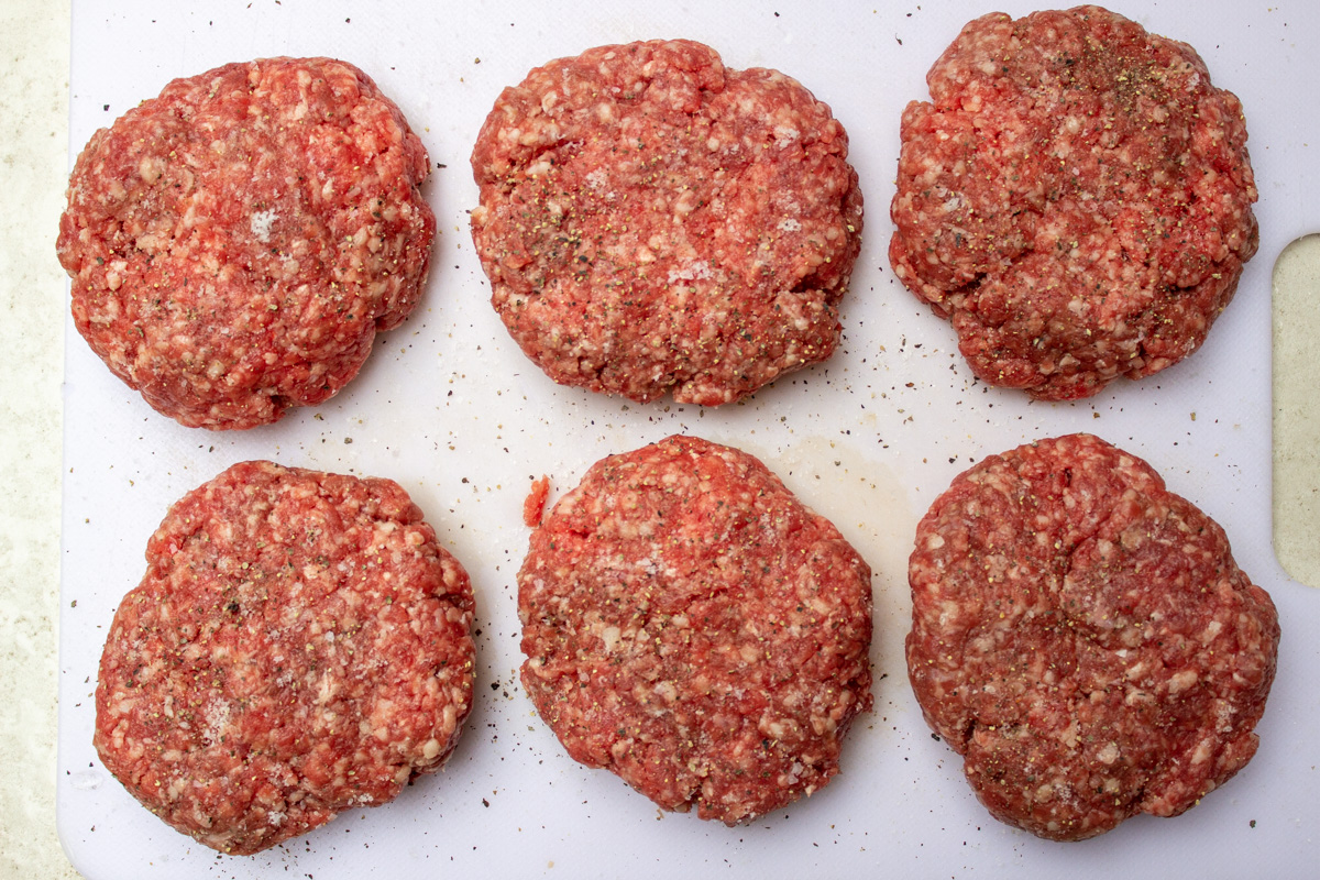 hamburger patties on cutting board