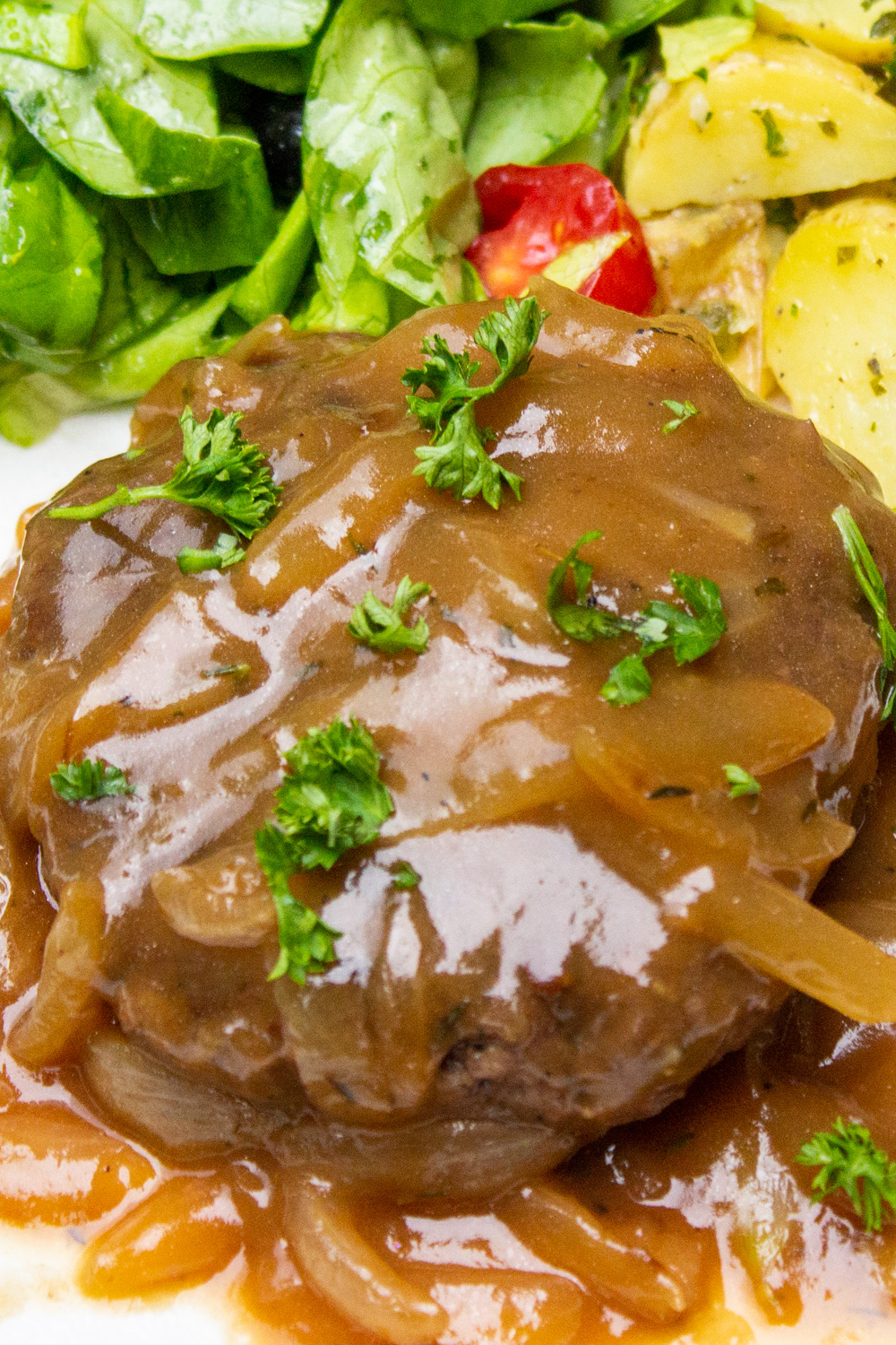 one sous vide hamburger steak on plate with onion gravy p