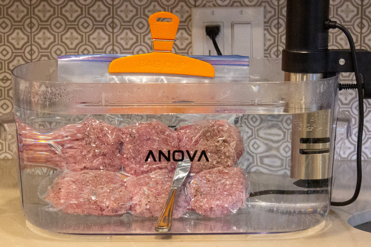 hamburger steaks in sous vide container filled with water
