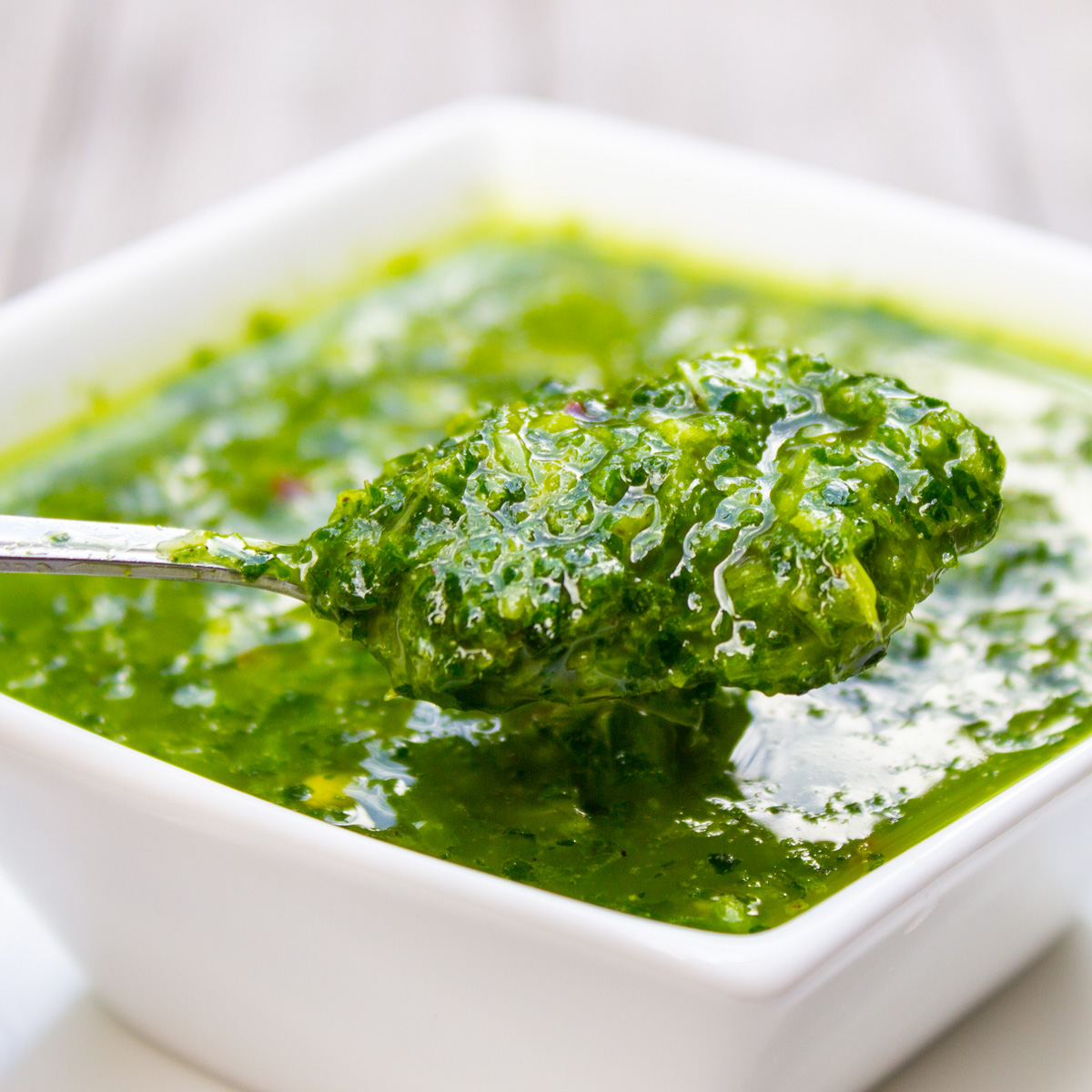 small white dish of herb sauce with spoon