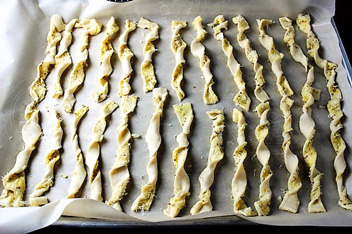 corkscrew straws of cheese twists lying on lined pan