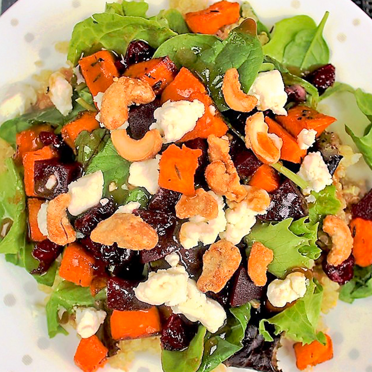salad with quinoa sweet potato nuts and goat cheese on plate