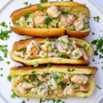 3 shrimp salad rolls on white plate sprinkled with parsley