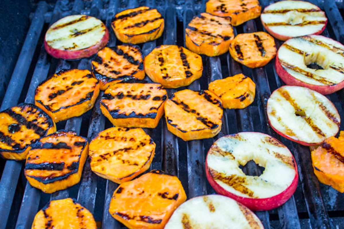slices of sweet potato and apples on grill with char marks