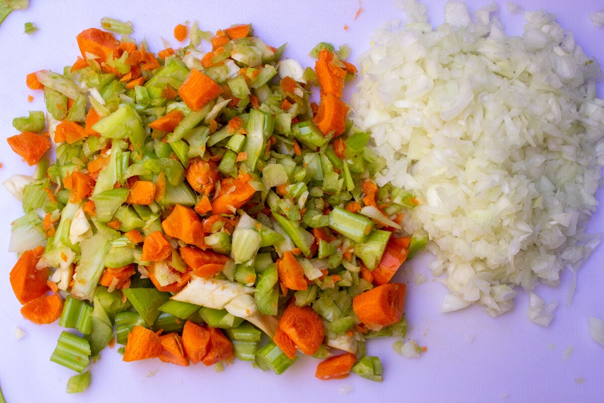 Chopped onion, carrots, celery on cutting board