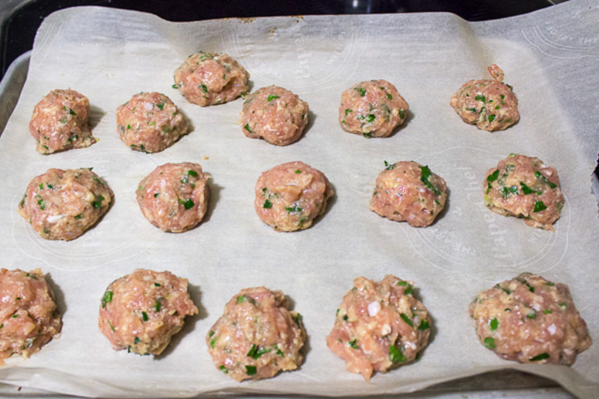 meatballs uncooked on parchment lined pan
