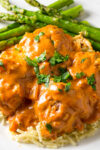 chicken meatball paprikash over egg noodles on plate with asparagus