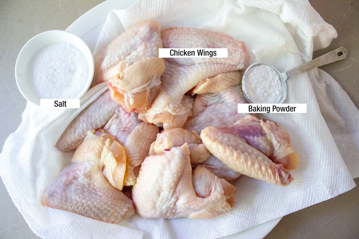 raw whole chicken wings on paper towels, baking powder, salt