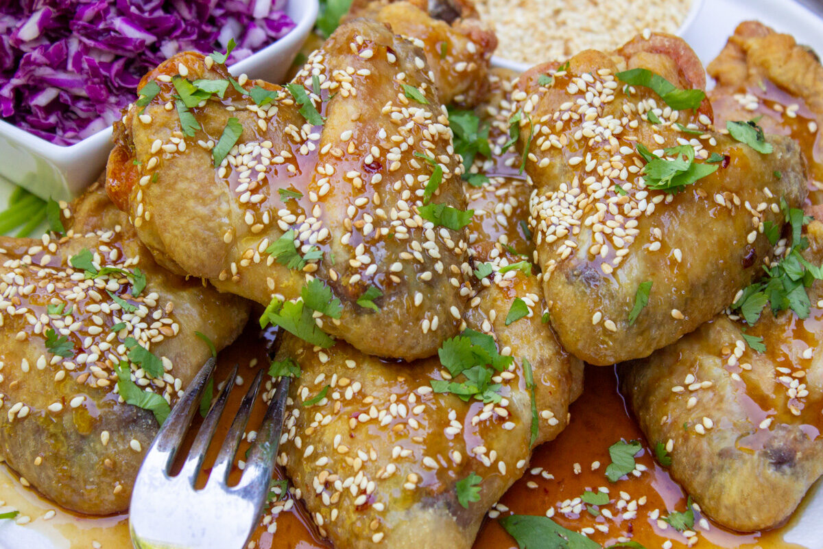 chicken wings on plate with honey garlic sauce and sesame seeds