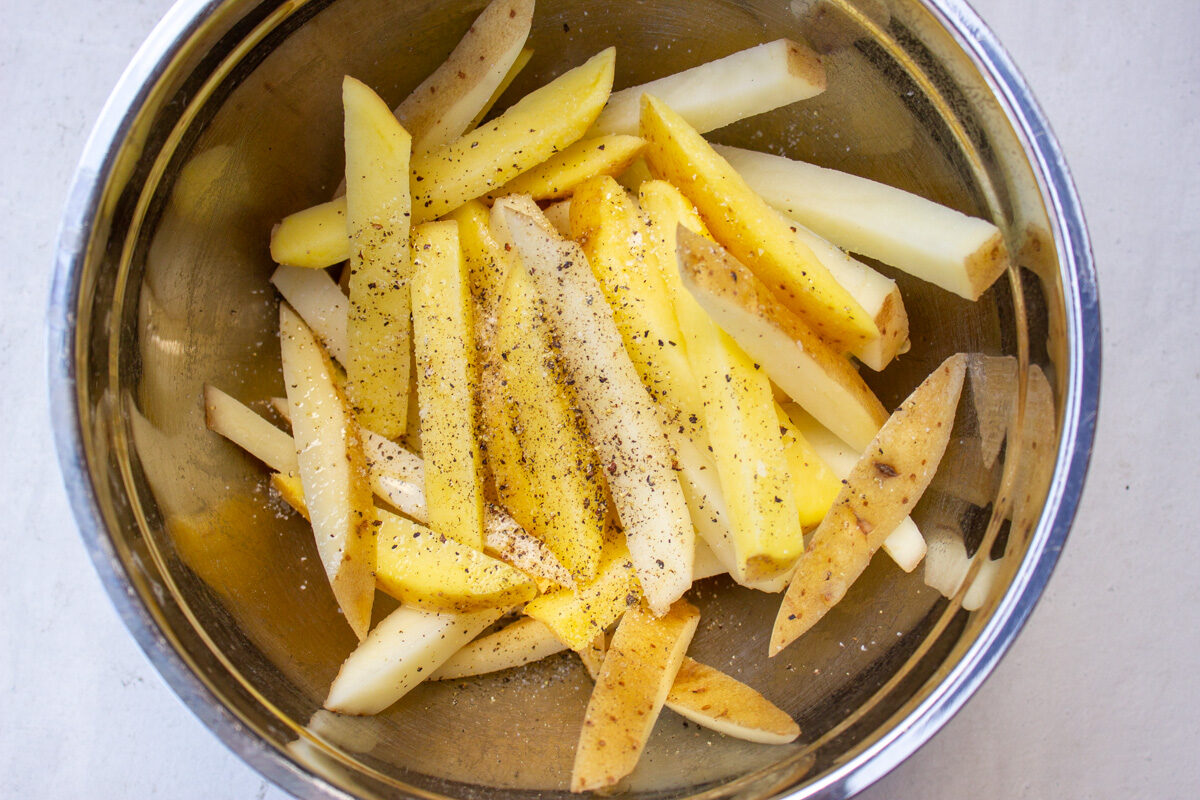 fry cut potatoes in bowl with seasonings
