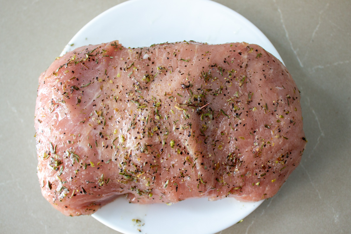 raw seasoned pork loin on plate
