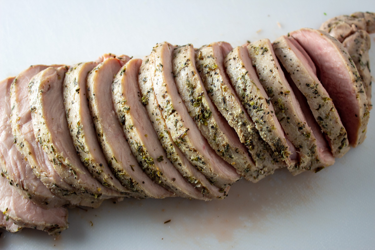 sliced cooked sous vide pork loin on cutting board