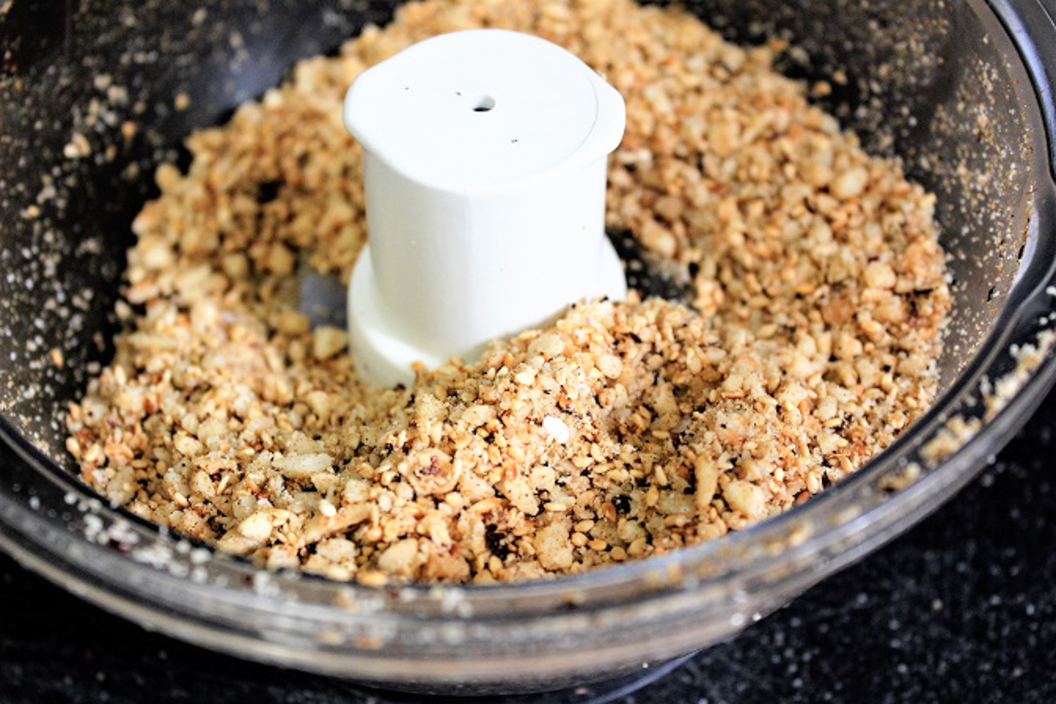 ground nuts and seeds in food processor bowl.