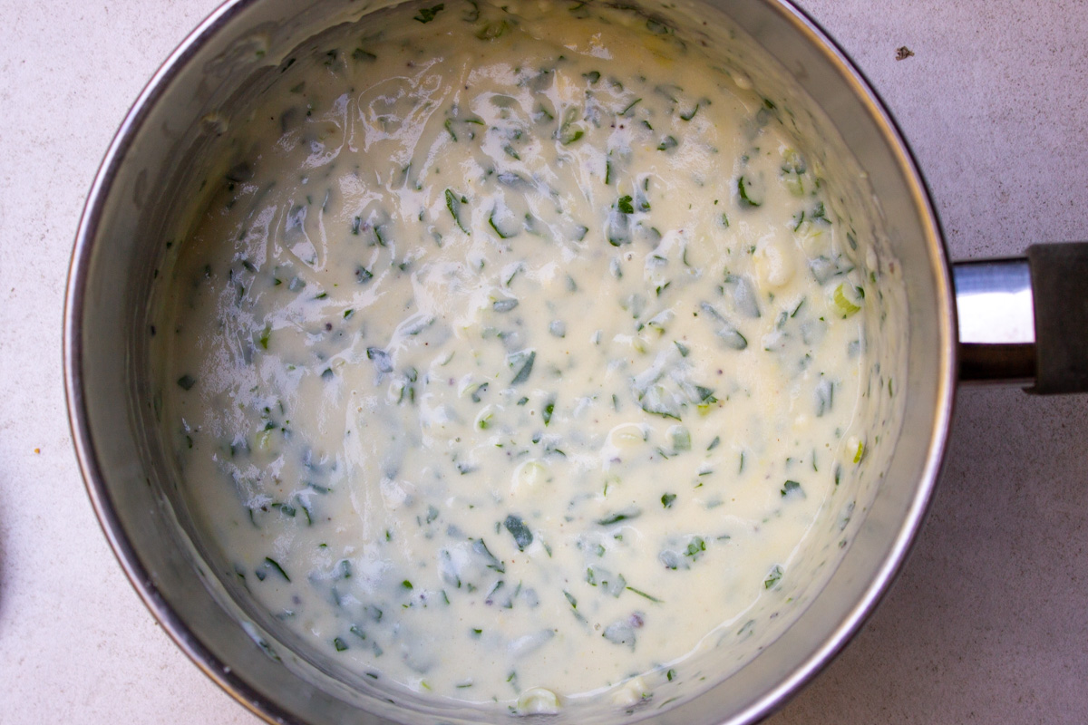 bechamel sauce with parsley and green onions in sauce pan