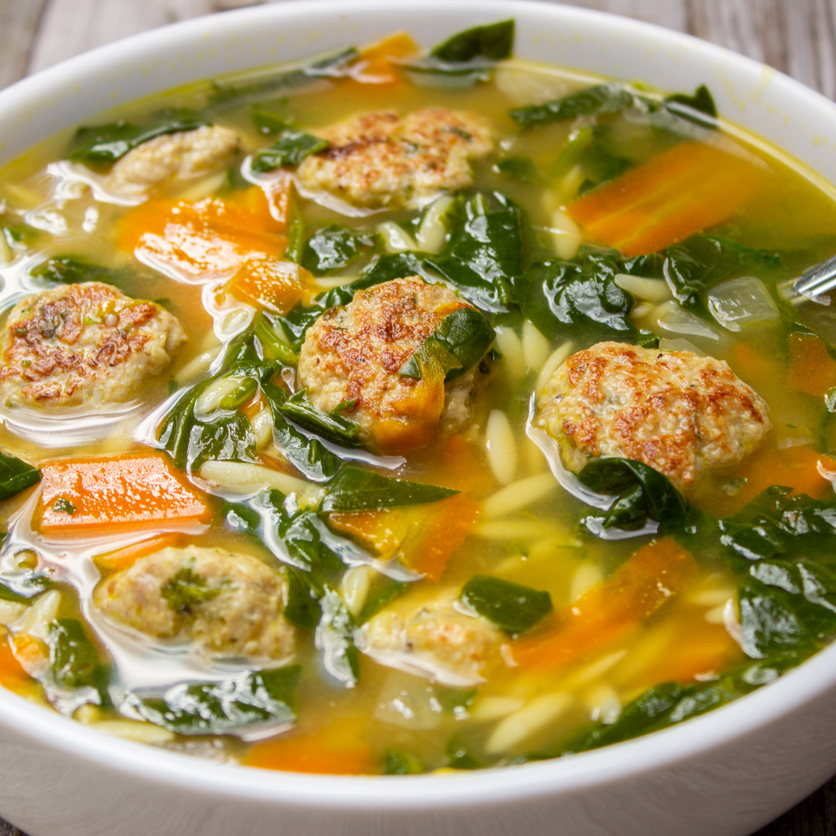 bowl of chicken meatball soup on wooden table