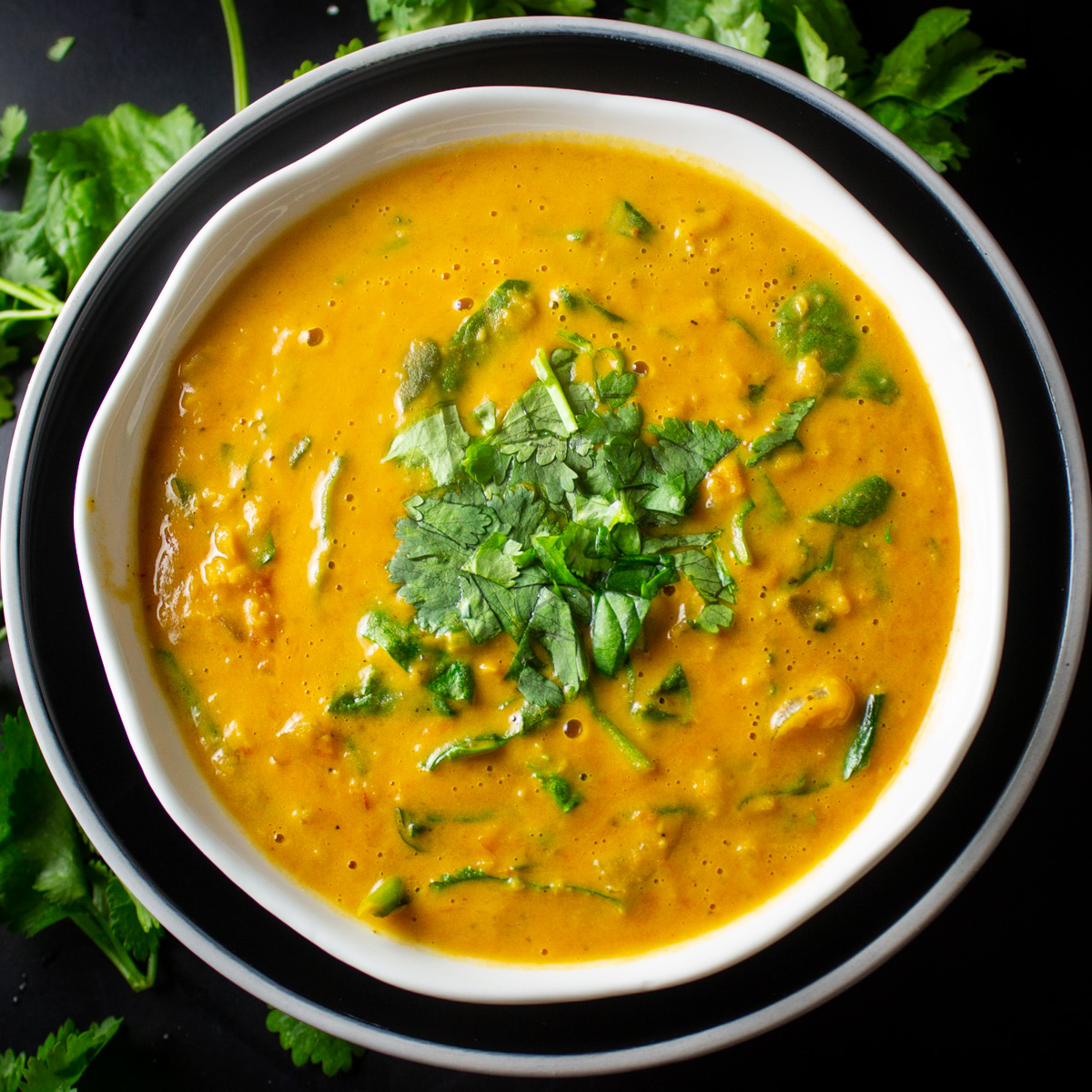 bowl of curried lentil soup with cilantro garnish..