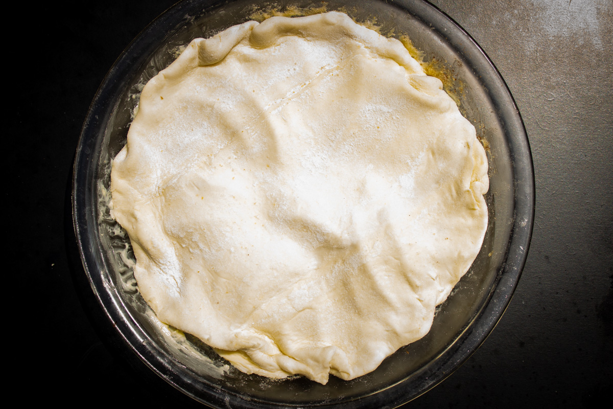 puff pastry dough draped on top of apples sugar and butter