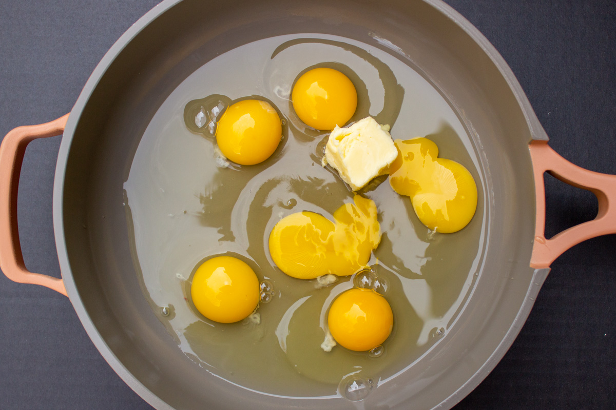 6 cracked raw eggs and butter in skillet