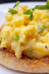 scrambled eggs on English muffin on plate.