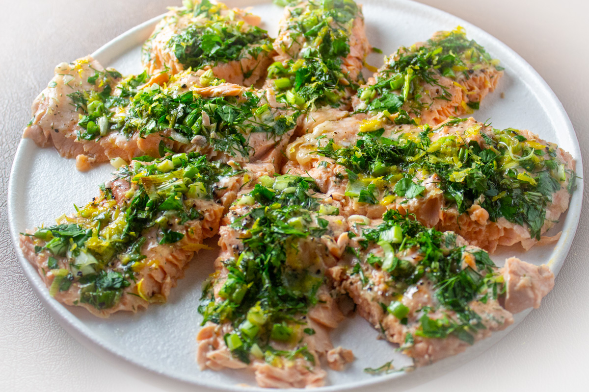8 pieces of trout topped with herb lemon mixture on plate