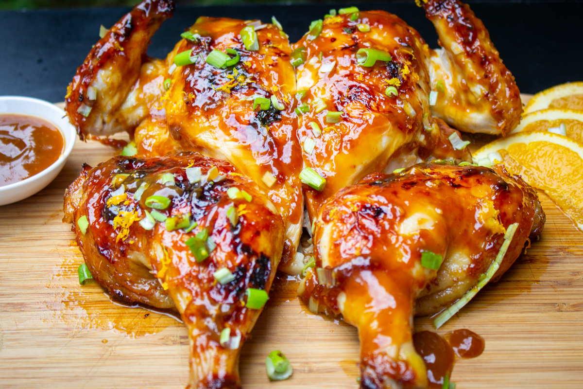 butterflied chicken with glaze on cutting board