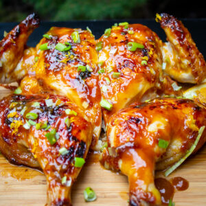 butterflied chicken with glaze on cutting board