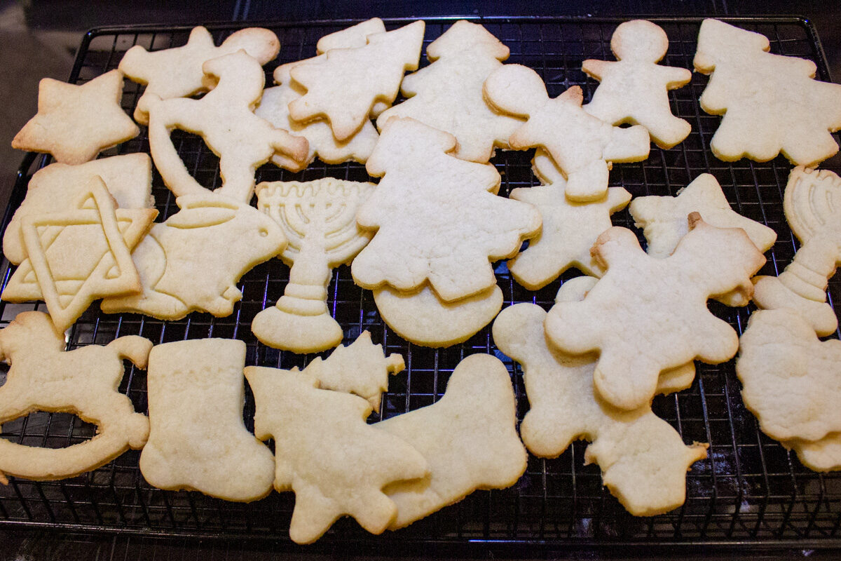 pile of baked cut out sugar cookies on cooling rack