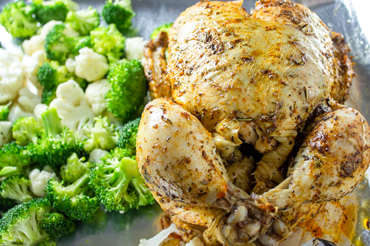 whole chicken on pan cooked in instant pot with broccoli beside it