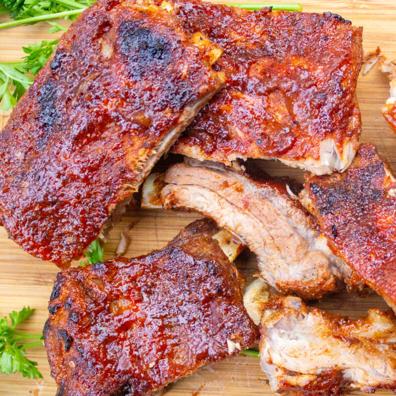 pieces of glazed cooked ribs on cutting board