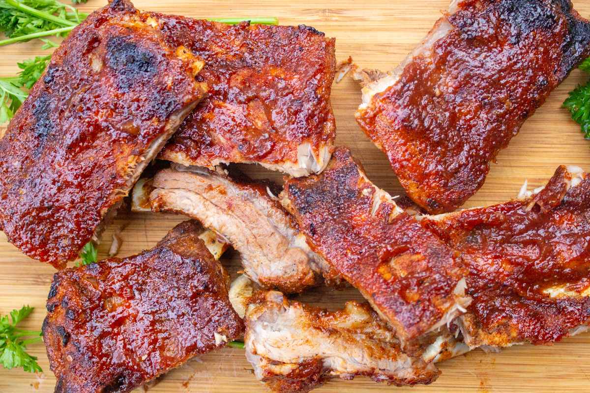 pieces of glazed cooked ribs on cutting board