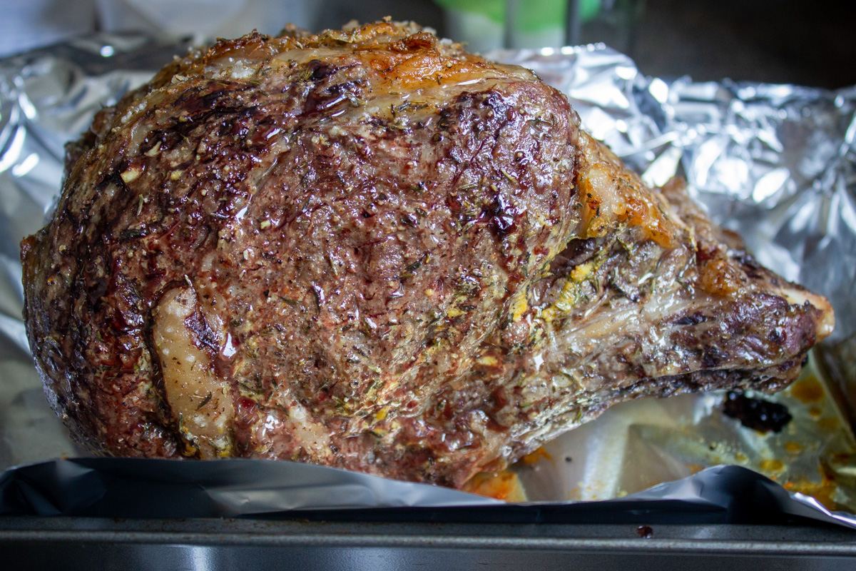 slow roasted prime rib in pan with foil, resting.