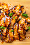 grilled glazed chicken thighs on cutting board