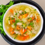 bowl of turkey soup with vegetables and noodles.