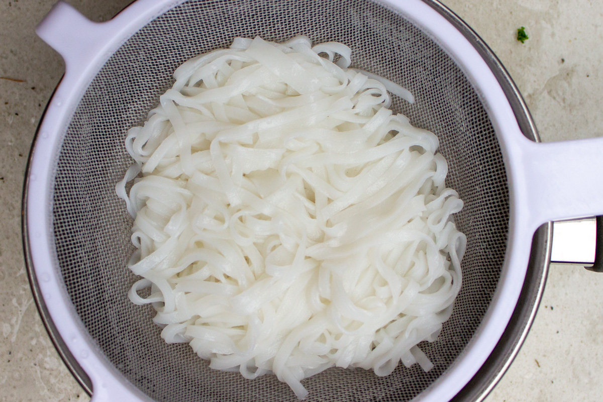 cooked rice noodles in colander.