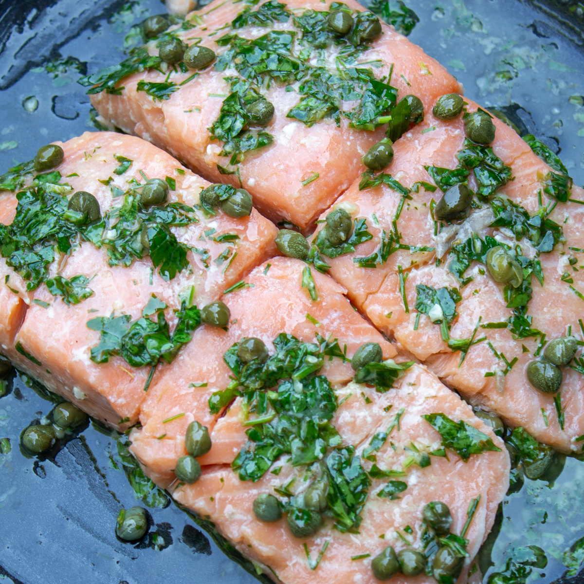 4 salmon pieces in pan with caper sauce