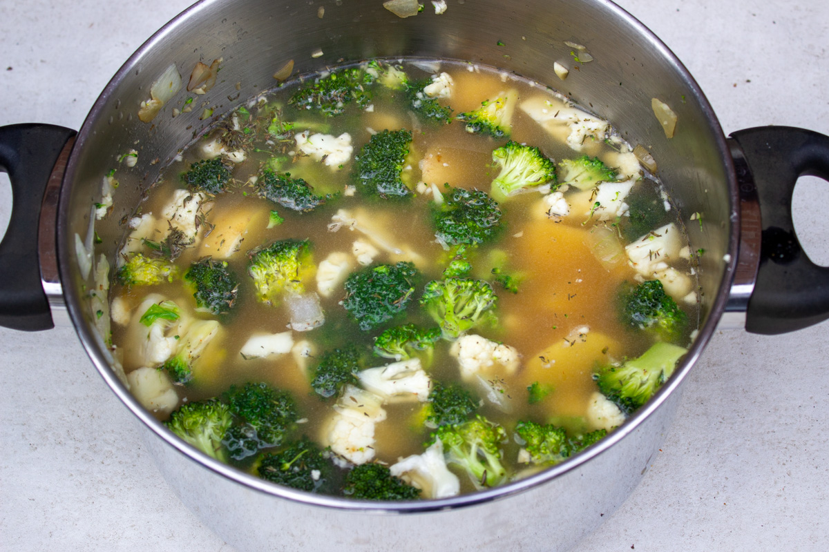 broccoli, cauliflower, onions, seasonings and broth in pot.