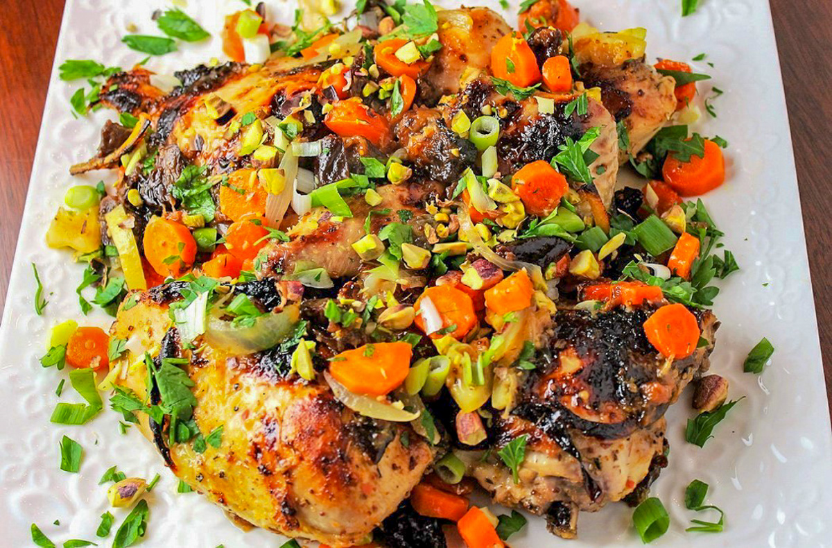 roasted chicken with carrots citrus prunes and pistachios on plate