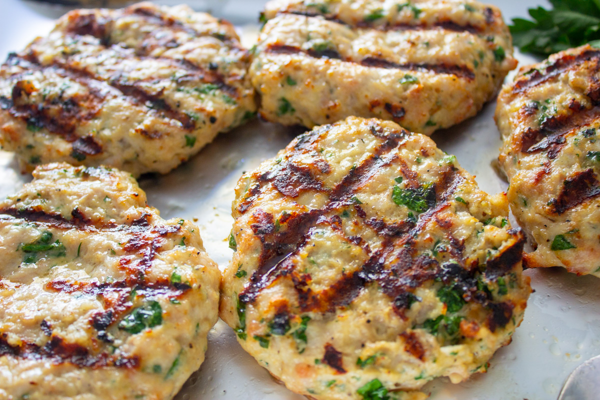 grilled chicken burgers on tray.