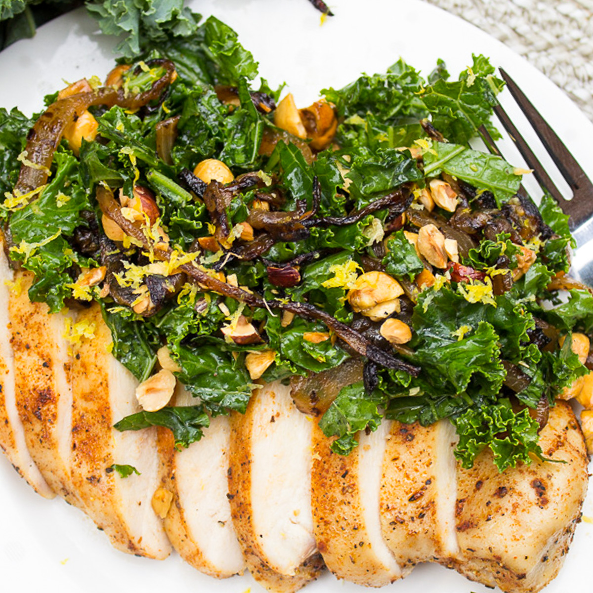kale slaw topping a sliced cooked chicken breast.