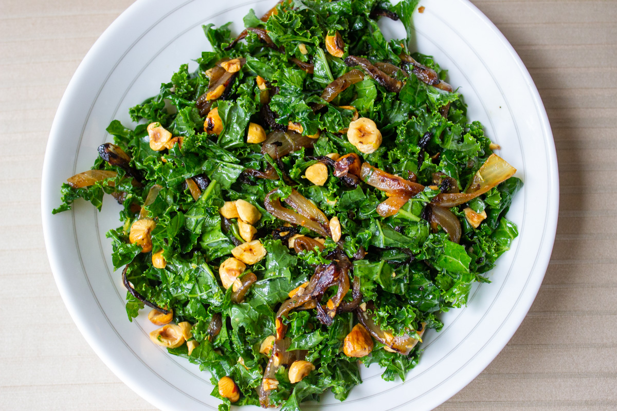 kale slaw with onions and hazelnuts in a bowl.