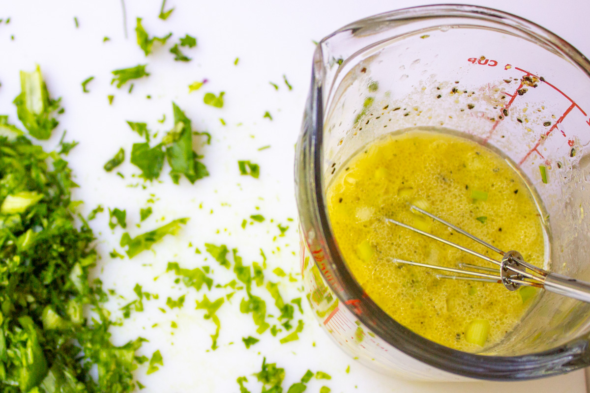 vinaigrette dressing in small cup and chopped green onion.