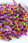 grilled purple cabbage slaw on white plate.,