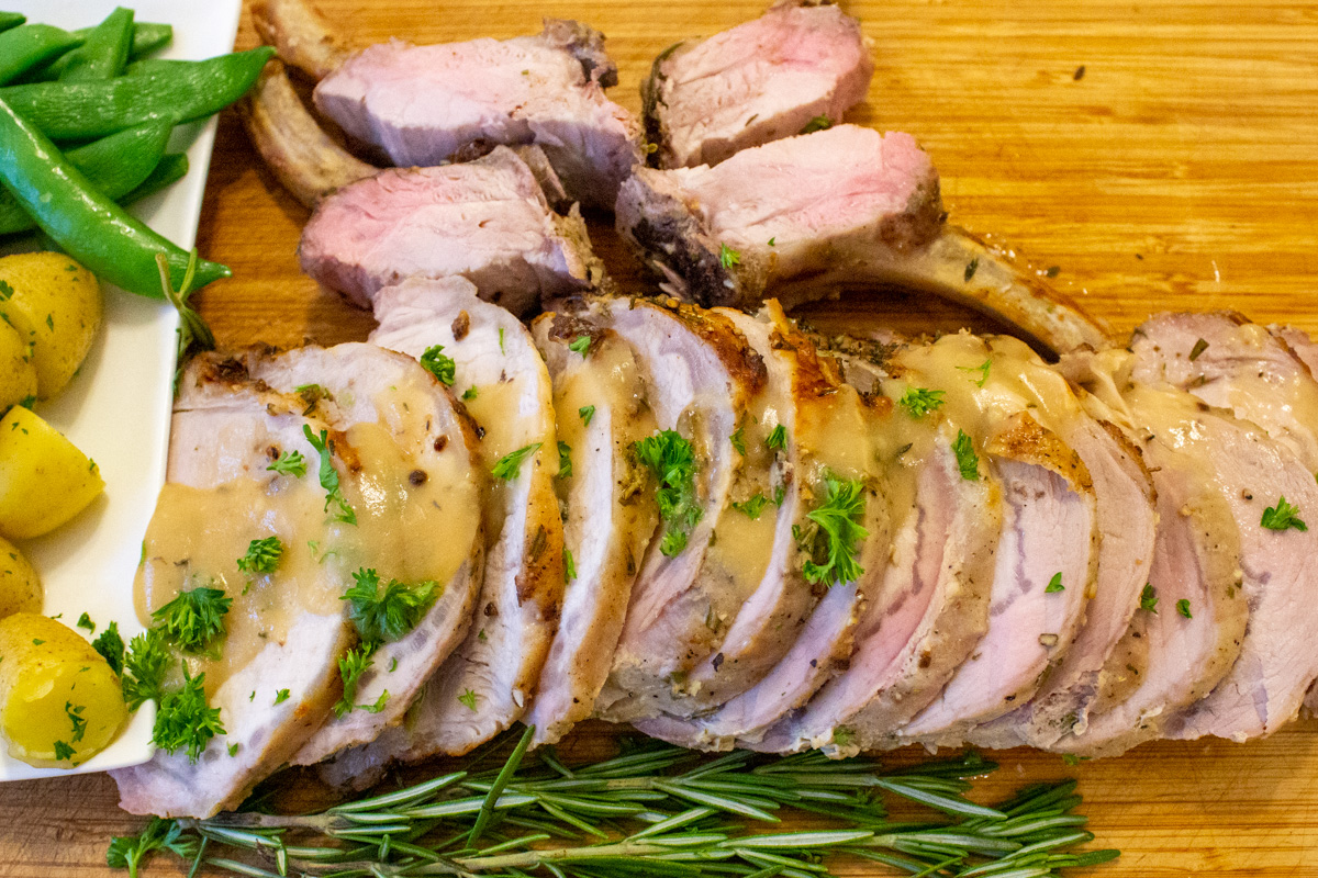 sliced rack of pork roast on cutting board.