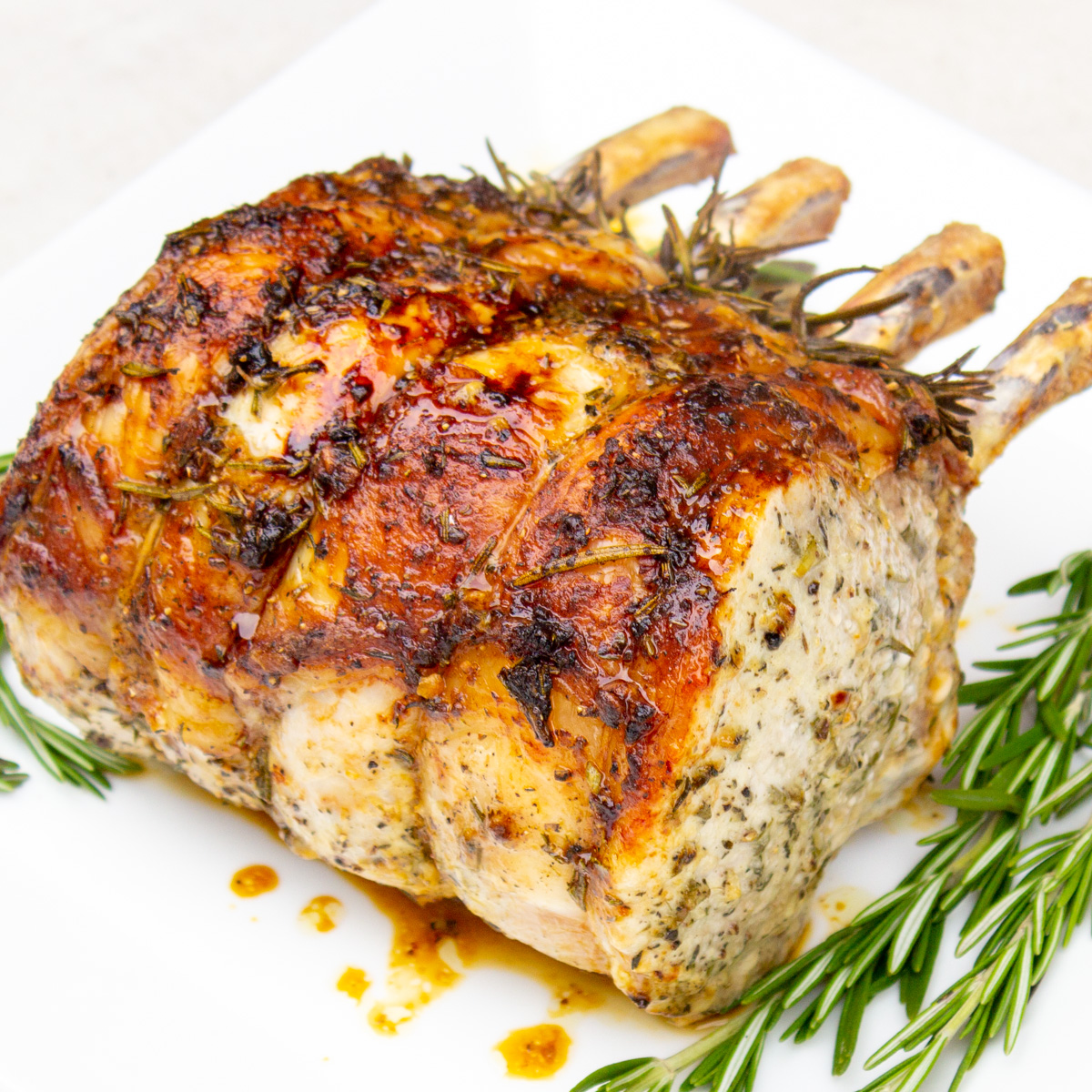 roasted rack of pork with rosemary on plate