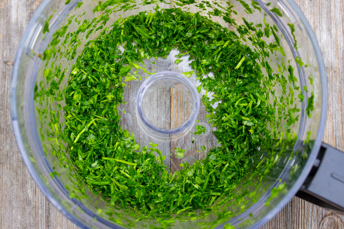 chopped herbs in food processor bowl.