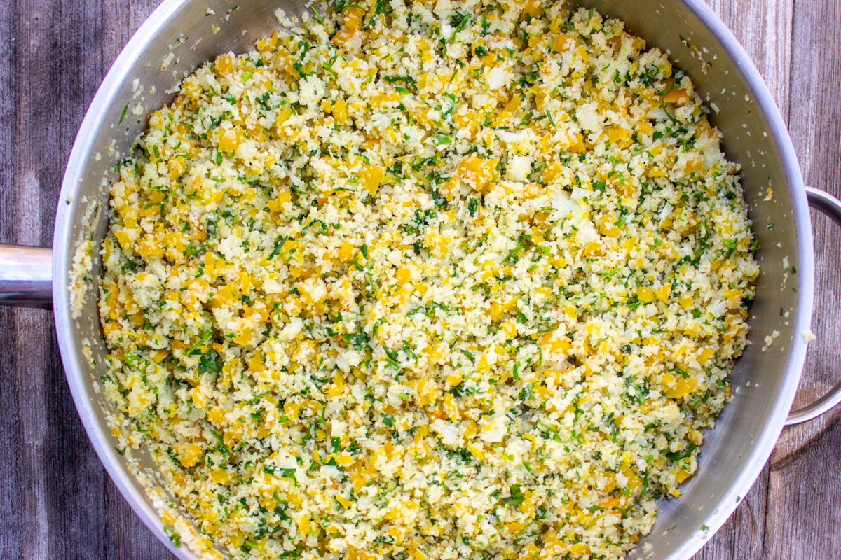 cauliflower rice with herbs and lemon in skillet.