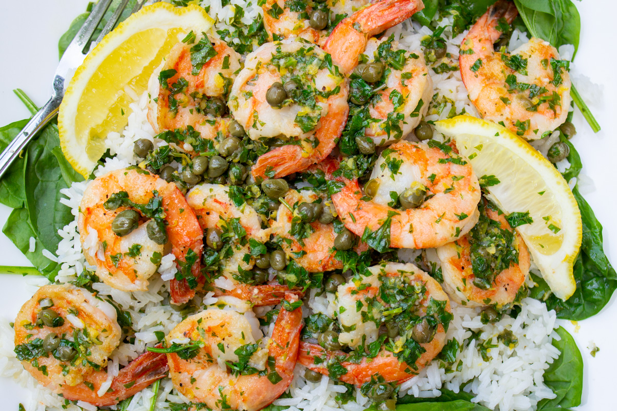 plate of shrimp piccata over rice.