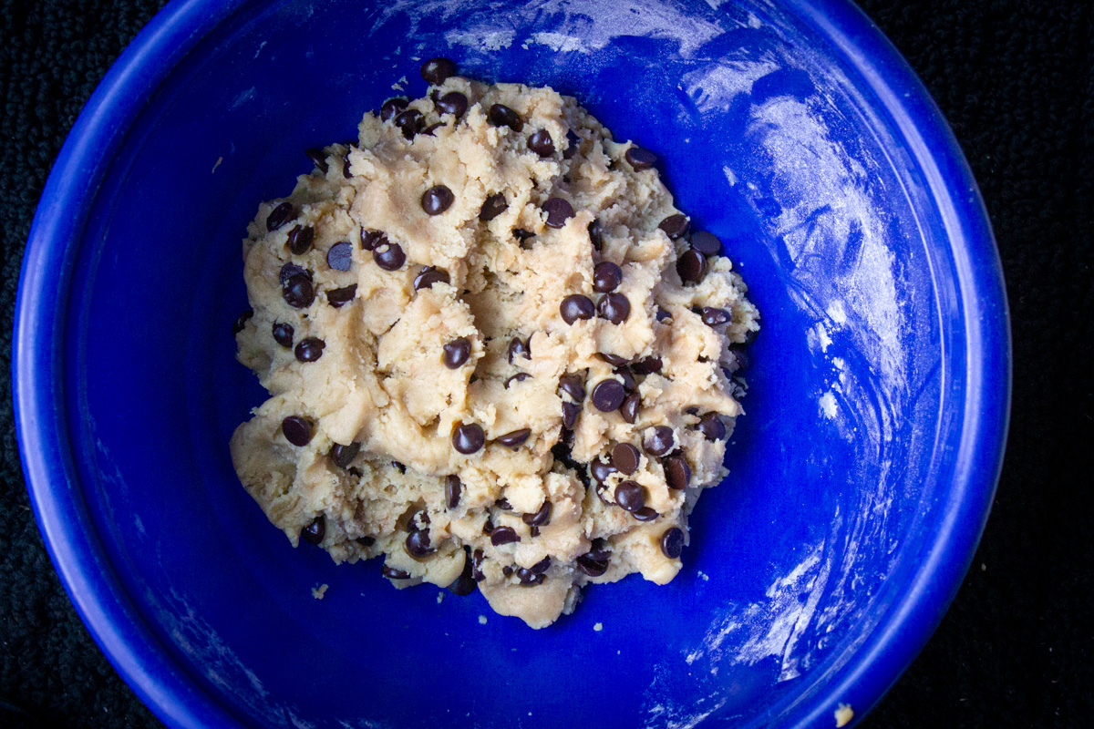 cookie dough with chocolate chips in mixing bowl.